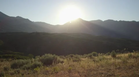 Static Shot of Man Walking up to Face the Sunset Over Mountains 動画素材 68723666