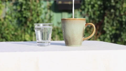 Static shot of milk being poured into a cup of coffee. Stock Footage 331763261