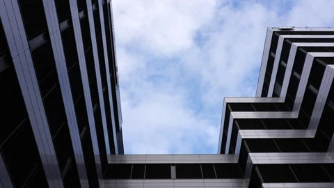 Static shot of modern office building exterior while white clouds move Stock Footage 257690625