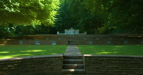 Static shot of multiple graves in green forest cemetery, large crypt at Stock Footage 138546452