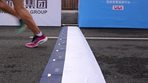 Static shot of multiple runners crossing the finish line at Beijing E-Town Stock Footage 310073722
