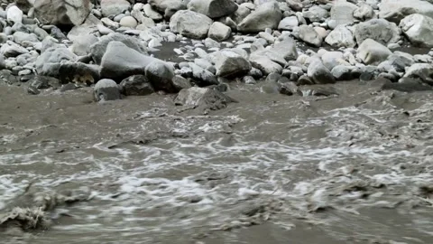 Static shot of murky water in river rapids and rocks on river bank Stock Footage 153802311