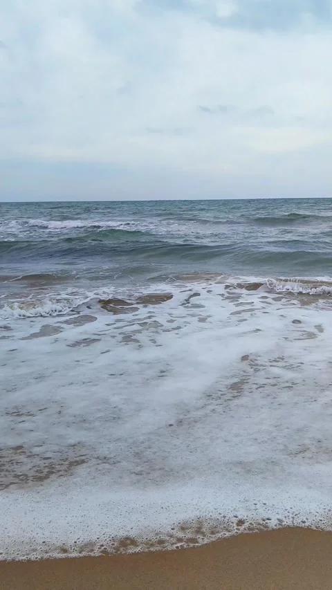 Static shot of the ocean with calm waves reaching the shore of a white sand Stock Footage 274456872