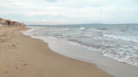 Static shot of the ocean with calm waves reaching the shore of a white sand Stock Footage 274456876