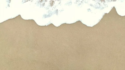 Static shot of the ocean with calm waves reaching the shore of a white sand Stock Footage 274456896