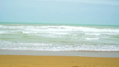 Static shot of the ocean with calm waves reaching the shore of a white sand  Stock Footage 284444585