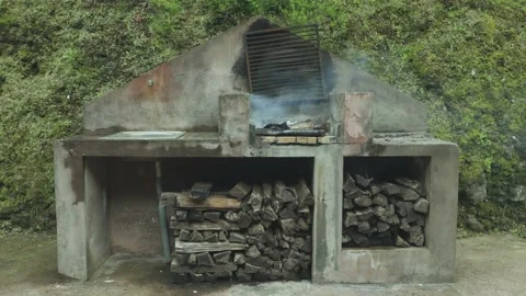 Static shot of an old wood-burning grill after use. Smoke billows. 库存影片 203426679