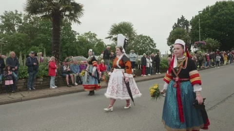 Static shot, overcast day: Breton traditional women in colorful costumes parade Video stock 341314316