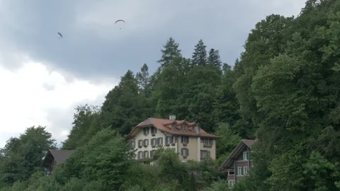 Static Shot Overcast Paragliders Over Swiss Chalet Interlaken Stock Footage 333789063