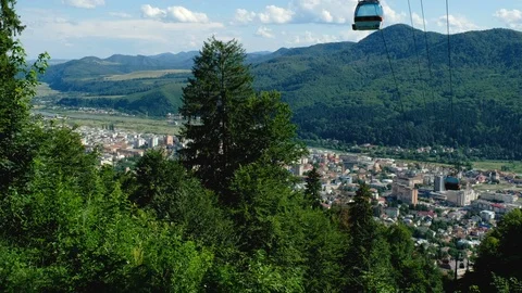 Static shot overlooking a city with the cable car passing overhead Stock Footage 94144315