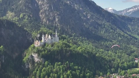 Static Shot of Paraglider Flying Across Frame with White Castle in Green Stock Footage 275263771