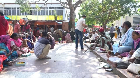 Static shot people distributing prasad to beggars outside Hanuman Mandir Stock Footage 165099323