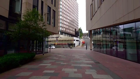 Static shot of a person walking between two modern buildings Stock Footage 200262173