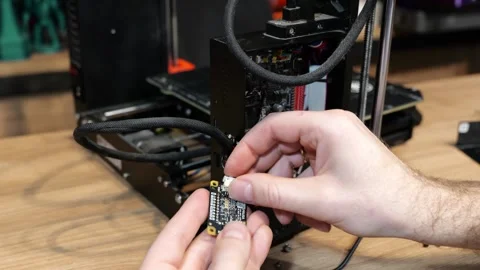 Static shot of a person working and repairing a 3D Printer. Stockbeeldmateriaal 336961085