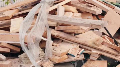 Static shot of a pile of scrap lumber, plastic materials, nails, and Stock Footage 345240473