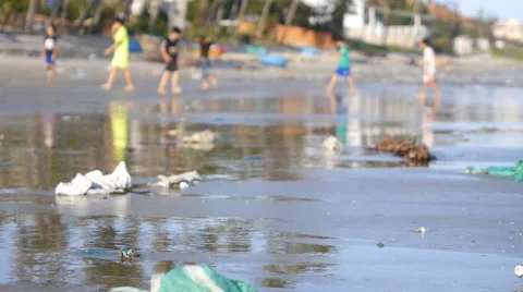 Static shot of playing children in defocus on beach polluted by trash Stock Footage 50788704