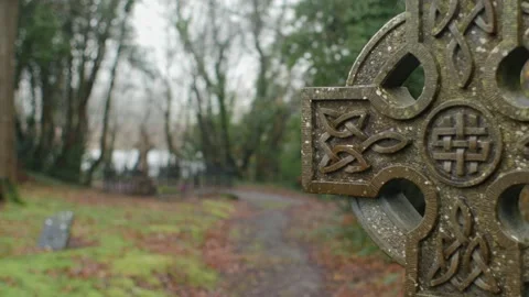 Static shot with pull focus on Celtic cross, isolated grave visible in Stock Footage 278504949