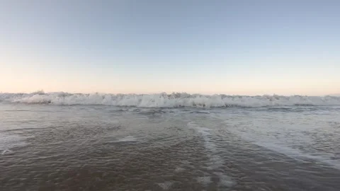 Static shot of returning water and waves breaking on beach shore Stock Footage 304280233