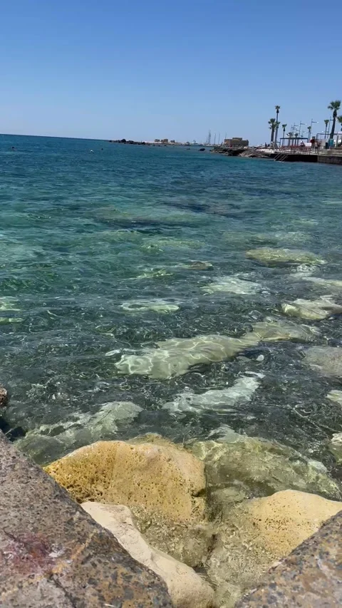 Static shot of a rocky coastline with clear blue sea water and horizon Stock Footage 336278514