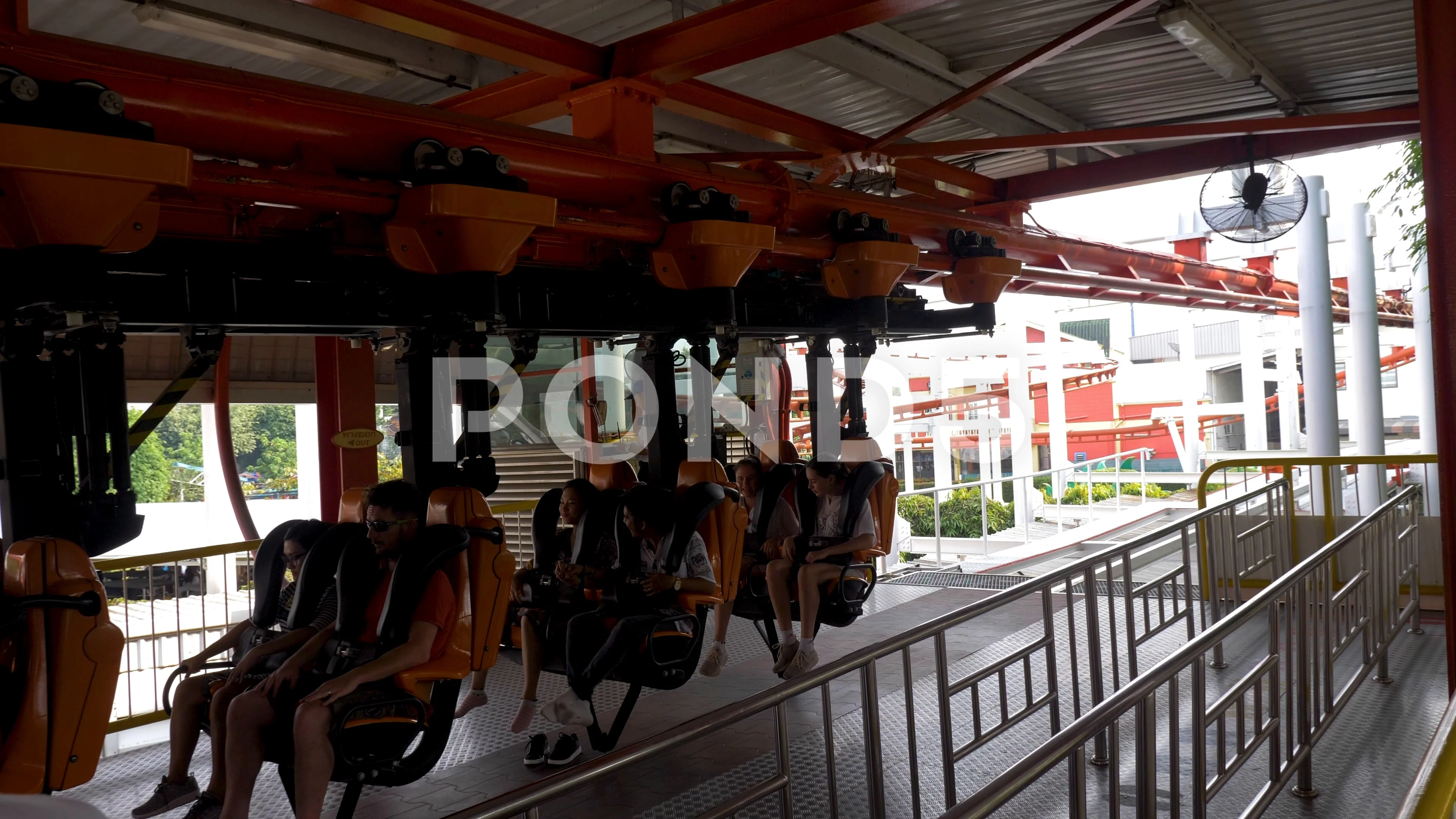 Static shot of a Roller Coaster carriage moving out of the station. Orange