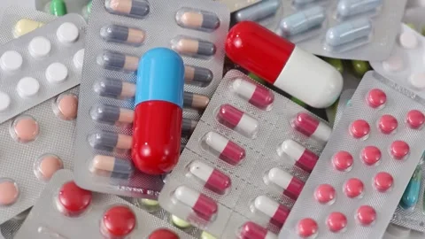 Static shot of rotating big pills on pile of medicine blisters Stock Footage 280677539