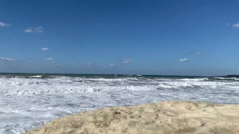 Static shot of the sea with calm waves reaching the shore of a white sand beach Stock Footage 220424809