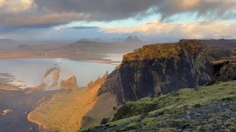 Static shot of sea cliffs and coastal lagoon with sunset sky reflections an.. Stock Footage 327683786