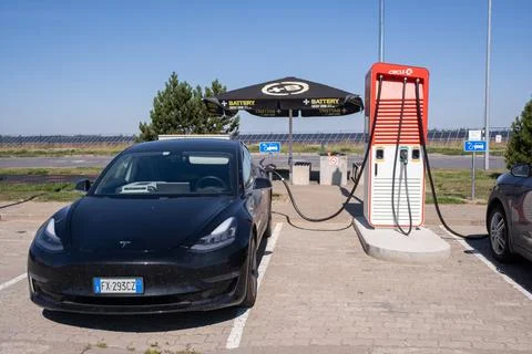 A static shot of a solid black Tesla Model 3 charging at the CircleK HPC Stock Photos