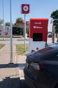 A static shot of a solid black Tesla Model 3 charging at the CircleK HPC Stock Photos