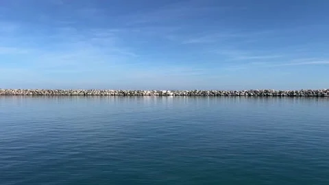 A static shot of a stone breakwater between calm sea and blue sky in Pieria.. Stock Footage 321065549