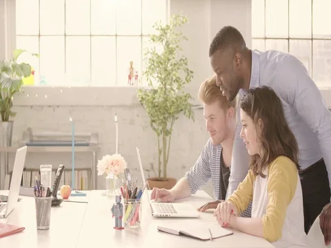 Static shot of table in casual sunny startup office with young happy adults Stock Footage 72883647