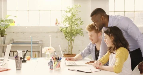 Static shot of table in casual sunny startup office with young happy adults Stock Footage 92192109