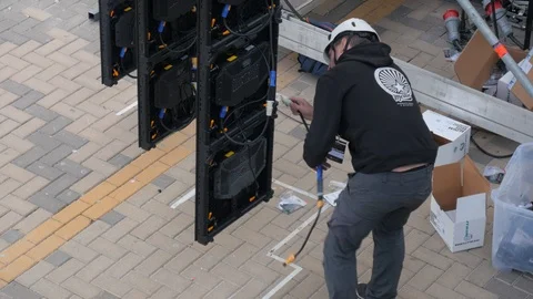 Static shot of a technician assembling a big outdoor lcd panel Stock Footage 123405300