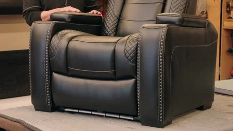 Static Shot of Technician Posing Beside Large Black Leather Chair on Workbench Stock Footage 308940005