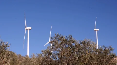 Static shot of three windmills on top of a hill in Mediterranean landscape, Video stock 120029779