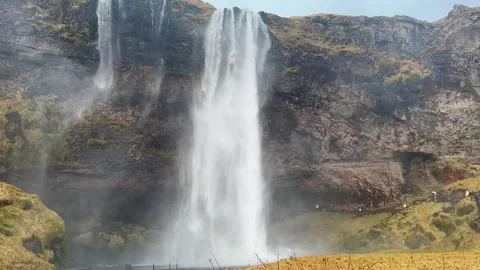 Static Shot of Tourists Walking Towards Seljalandsfoss Waterfall, Iceland. Stock Footage 327673070