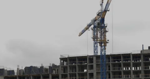 Static Shot of Tower Crane Swinging Over Unfinished Highrise Building Stock Footage 321056238