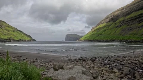 Static shot of volcanic coastline and green mountains under stormy sky Stock-Footage 339481911
