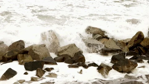 Static shot of waves breaking over large coastal rocks in Japan on overcast day Stock Footage 321105482