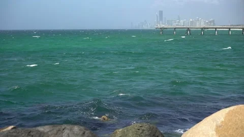 Static shot waves ocean with city in bac... | Stock Video | Pond5