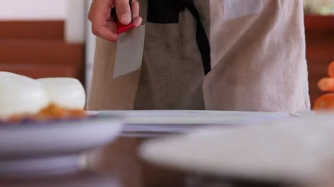 A static shot where hands of the chief hold a large knife and cut juicy bright Stock Footage 255811423