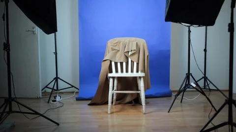 Static shot of white chair in empty photo studio surrounded by lights Stock Footage 98746769