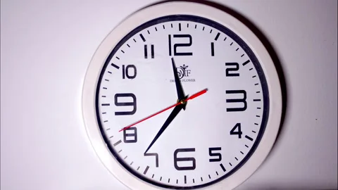 Static Shot of a White Wall Clock with a Metal Frame Showing the Time Stock Footage 337081656