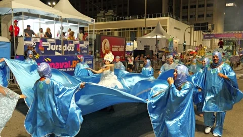 Static shot of a woman dancing in a large blue dress during Rio de Janeiro Stock Footage 336033567