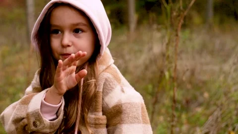Static shot of young girl talking in autumn forest setting Stock Footage 346622198