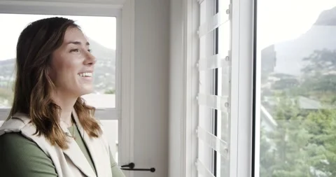 Static shutters drawing woman to window, folding arms and reflecting on mountain Vidéo 335069801