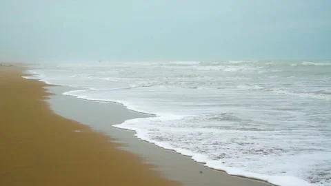 Static slow motion shot of the ocean with calm waves reaching the shore of a Stock Footage 284444840