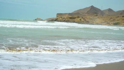 Static slow motion shot of the ocean with calm waves reaching the shore of a Stock Footage 284444960