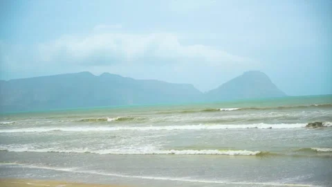 Static slow motion shot of the ocean with calm waves reaching the shore of a Stock Footage 284444964