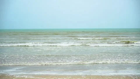 Static slow motion shot of the ocean with calm waves reaching the shore of a Stock Footage 284445229